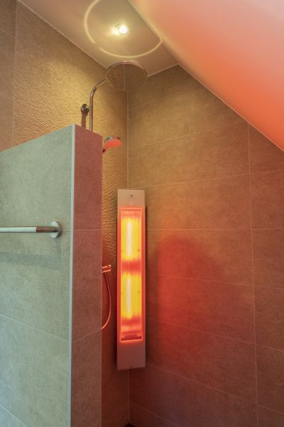 Modern shower with infrared lamp in Villa 19, a vacation home in De Koog, Texel.