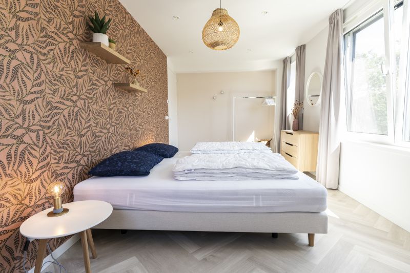 Villa 19 in De Koog, Texel, bedroom with unique wall decoration and lots of natural light.