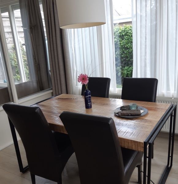 Eetkamer in De Anemoon, De Koog, Texel. Moderne tafel met comfortabele stoelen en veel natuurlijk licht.