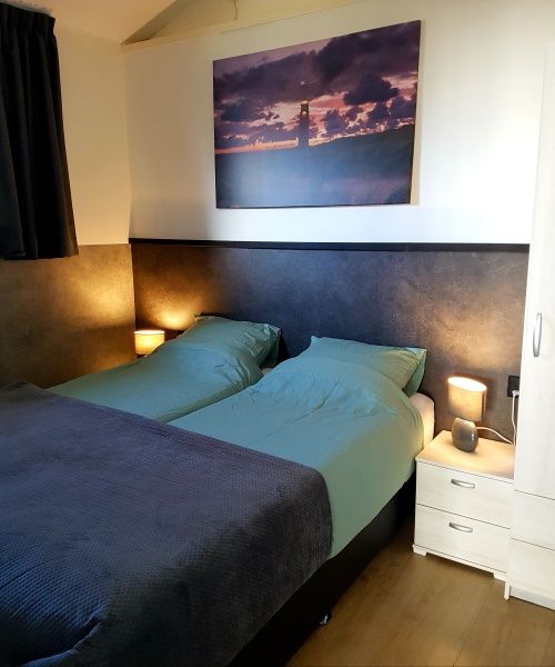 Hoofdslaapkamer in De Anemoon, De Koog, Texel. Comfortabele bedden en sfeervolle verlichting.