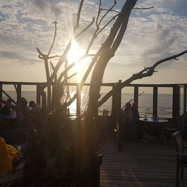 Zonsondergang bij terras in De Koog, Texel. Genieten van het uitzicht op zee nabij vakantiehuis De Anemoon.