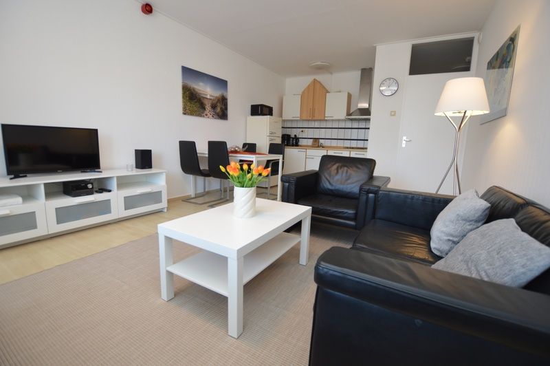 Stijlvolle woonkamer in Appartement Kerckeland 98, De Koog, Texel met open keuken en eetruimte.