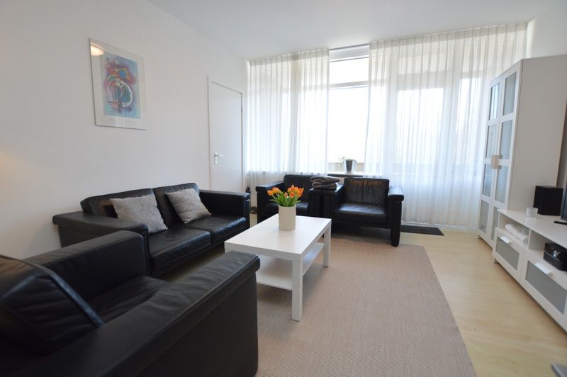 Ruime woonkamer in Appartement Kerckeland 98, De Koog, Texel met comfortabele banken en veel natuurlijk licht.