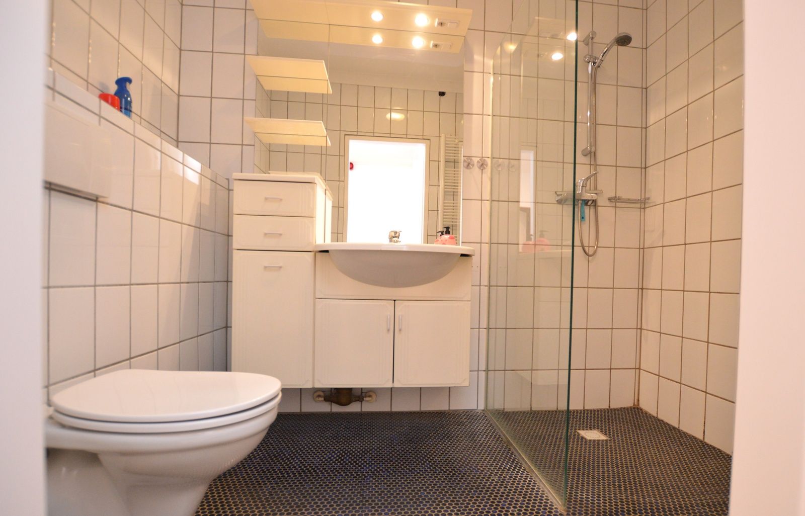 Ruime badkamer van Appartement Kerckeland 98, De Koog, Texel met eigentijdse inrichting en glazen douchewand.