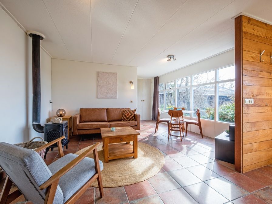 De Zonneweelde vakantiehuis in De Koog, Texel omgeven door groene natuur en zonlicht.