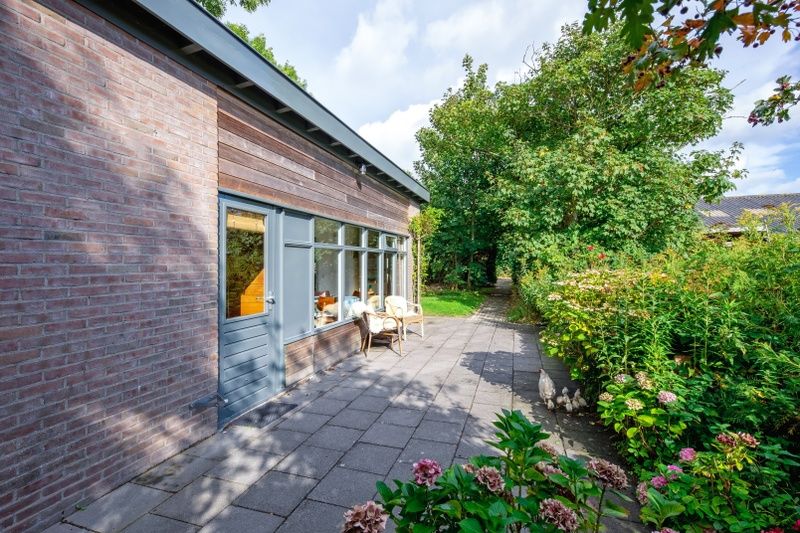 Veranda van De Zonneweelde vakantiehuis in De Koog, Texel met groene omgeving.