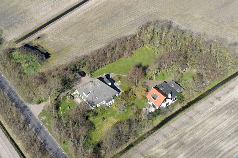 Luchtfoto van vakantiehuis Achterhuis in De Koog, Texel, met ruime groene omgeving.