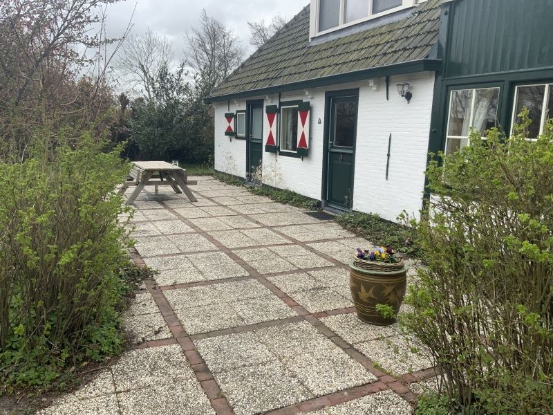 Zonnig terras bij vakantiehuis Achterhuis, De Koog, Texel, met picknicktafel.