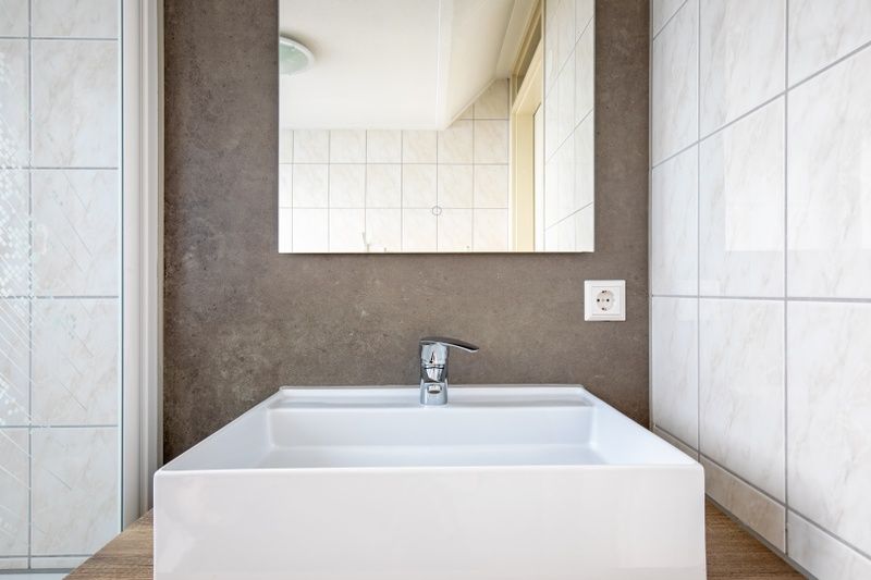 Strakke wastafel in de badkamer van Villa 5 De Koog Texel, een stijlvol vakantiehuis op de Waddeneilanden voor een comfortabel verblijf.