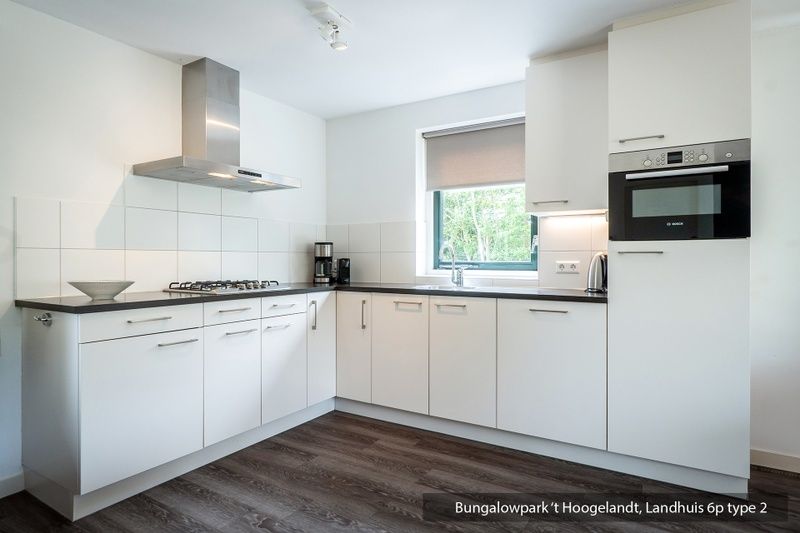 Schaduwrijke tuin bij Bungalowpark 't Hoogelandt vakantiehuis, De Koog, Texel met terras.