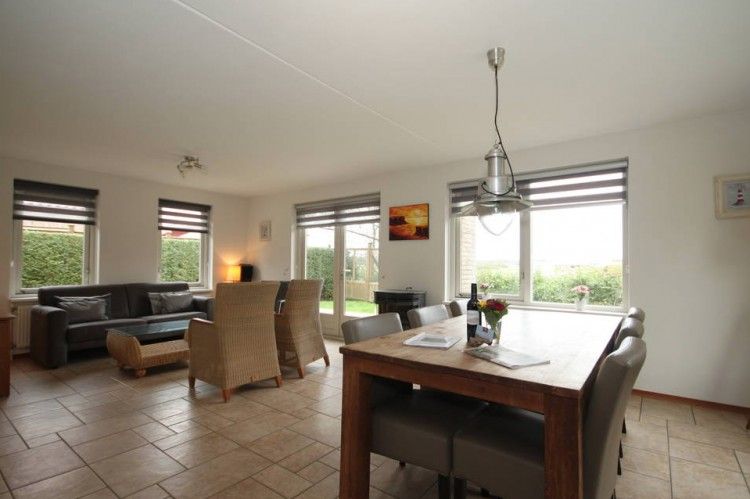 Ruime leefruimte in 6 Persoons luxe villa met sauna in De Koog, Texel, met uitzicht op de tuin.