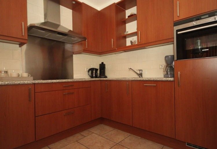 Moderne keuken in 6 Persoons luxe villa met sauna in De Koog, Texel, met houten kasten en apparatuur.