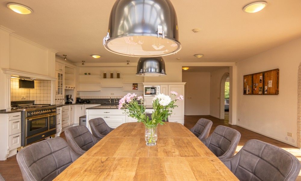 Stylish dining area with flowers in Kamerstraat 66 vacation home in De Koog Texel for cozy meals.