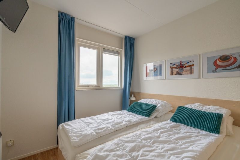 Slaapkamer met twee bedden in Appartement Juliana 146 Eiland en Zeezicht, De Koog, Texel met uitzicht op zee.