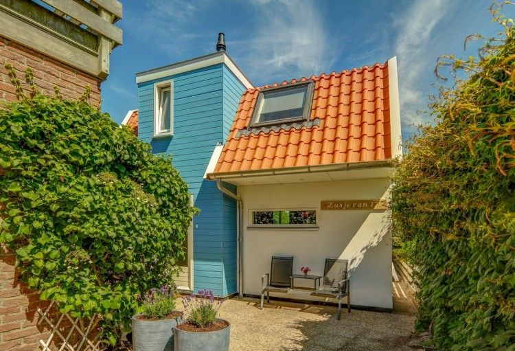 Charmant vakantiehuis Zusje van 17 in De Koog, Texel met kleurrijke gevel en gezellig terras.