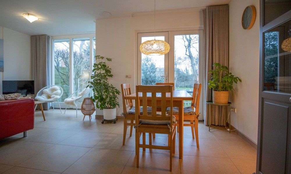 Ruime woonkamer van vakantiehuis Zusje van 17 in De Koog, Texel met veel licht en uitzicht op de tuin.