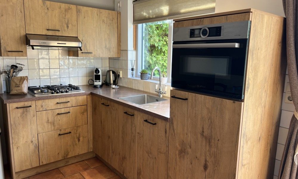 Gezellige eetruimte in Koetshuis vakantiehuis, De Koog Texel, met houten tafel en kleurrijke stoelen voor een ontspannen dinerervaring.