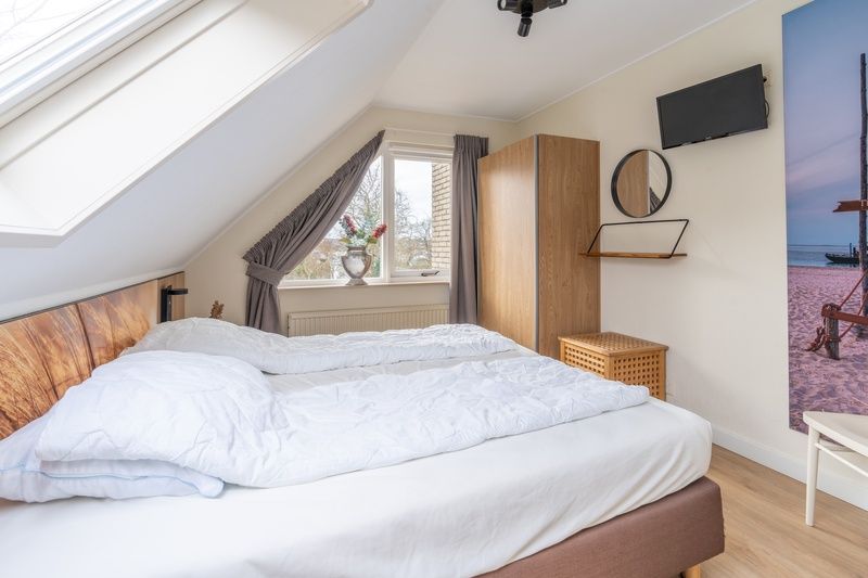 Gemuetliches Schlafzimmer im Ferienhaus Honeysuckle 33 in De Koog, Texel mit viel Tageslicht.