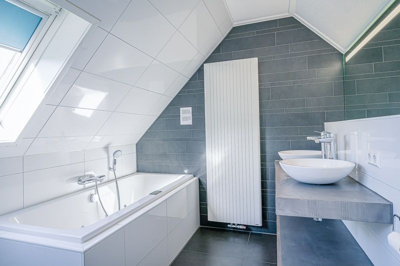 Luxury bathroom in Holiday home Kamperfoelie 95, De Koog, Texel with bathtub and modern sinks.