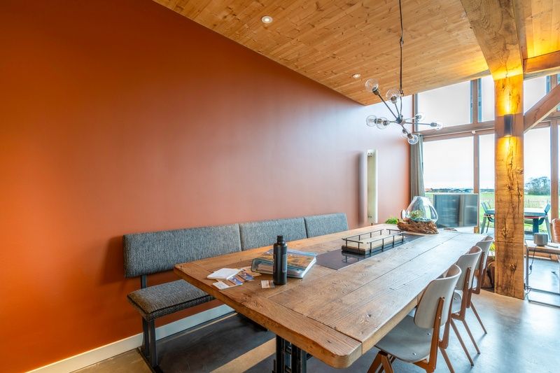 Dining area in Villa 191 with Hot tub, De Koog, Texel, with large wooden table and modern lighting.