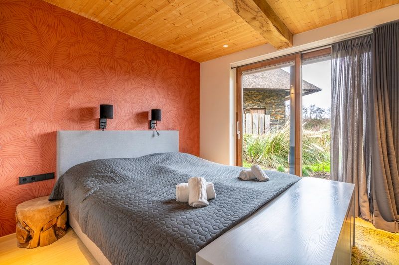 Attractive bedroom in Villa 191 with Hottub, De Koog, Texel, with warm colors and access to the garden.