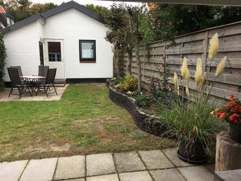 Rustikaler Garten des Ferienhauses Jutter in De Koog, Texel mit Sitzecke.