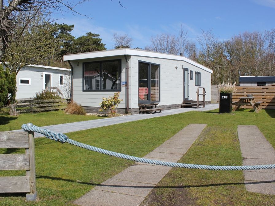 Chalet Bregkoog 208, een charmante vakantiewoning in De Koog, Texel, omgeven door groene tuinen en rustgevende natuur.