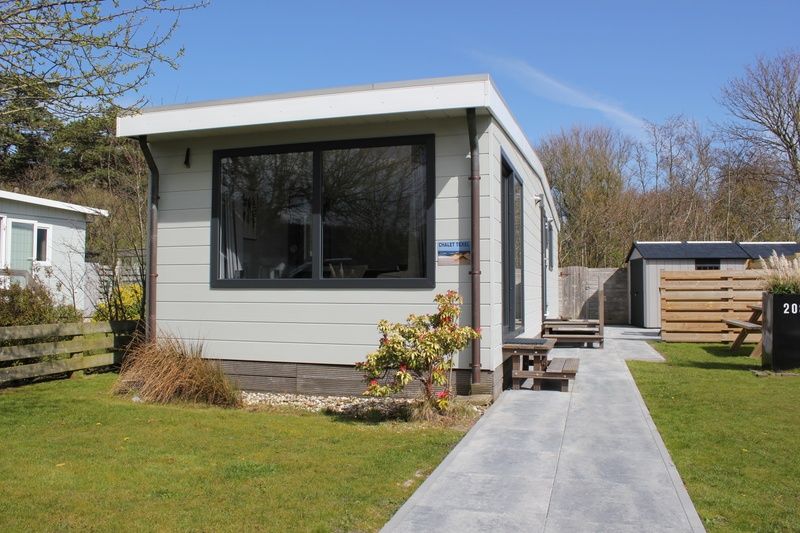 Chalet Bregkoog 208, een gezellig vakantieverblijf in De Koog, Texel, met een moderne uitstraling en omringd door groen.