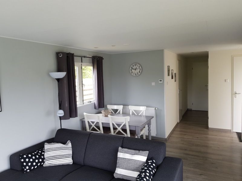 Gezellige woonkamer van Chalet Bregkoog 208, De Koog, Texel, met veel lichtinval en uitzicht op de tuin.