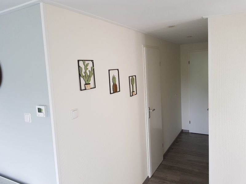 Hal van Chalet Bregkoog 208 in De Koog, Texel, met moderne decoraties en toegang tot de slaapkamers.