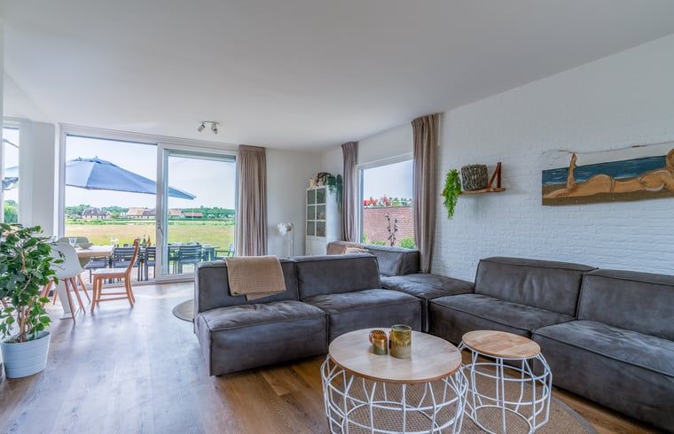 Gezellige woonkamer van Huisje in De Koog, Texel, met uitzicht op het landschap van de Waddeneilanden.