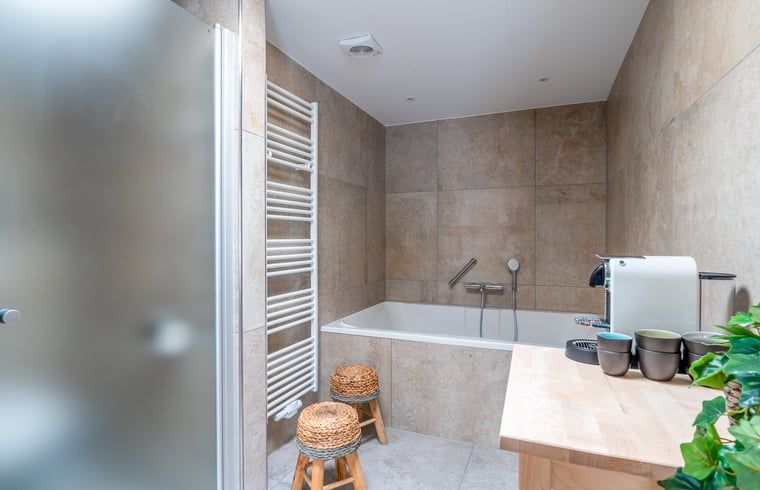 Luxe badkamer in Huisje in De Koog, Texel, met ligbad en moderne voorzieningen.