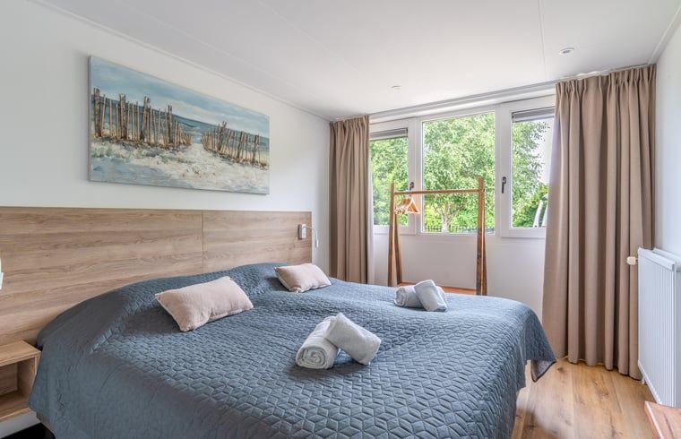 Comfortabele slaapkamer in Huisje in De Koog, Texel, met uitzicht op de natuur van de Waddeneilanden.