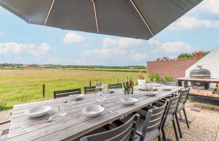 Buiten dineren bij Huisje in De Koog, Texel, met uitzicht op de prachtige natuur van de Waddeneilanden.