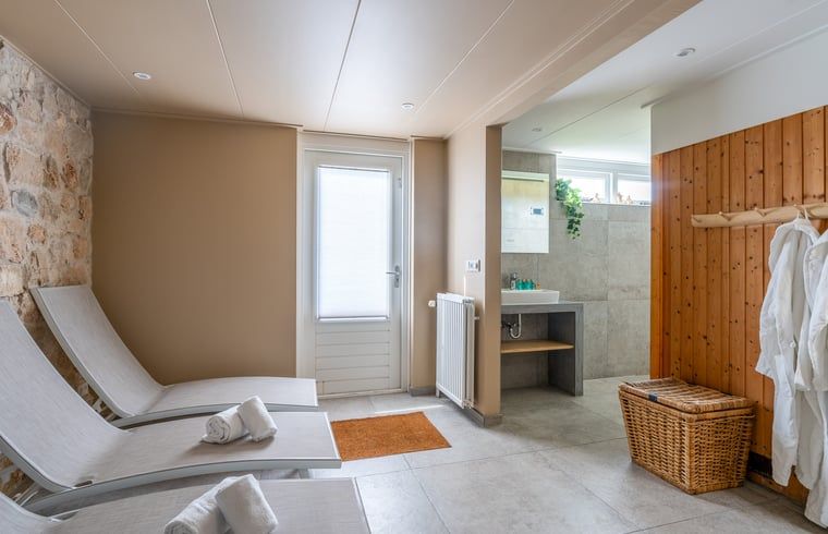 Wellnessruimte in Huisje in De Koog, Texel, met ligstoelen en toegang tot de tuin.