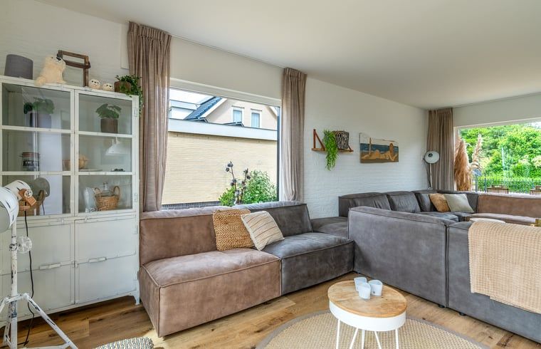 Gezellige zithoek in Huisje in De Koog, Texel, met uitzicht op de tuin en de Waddeneilanden.