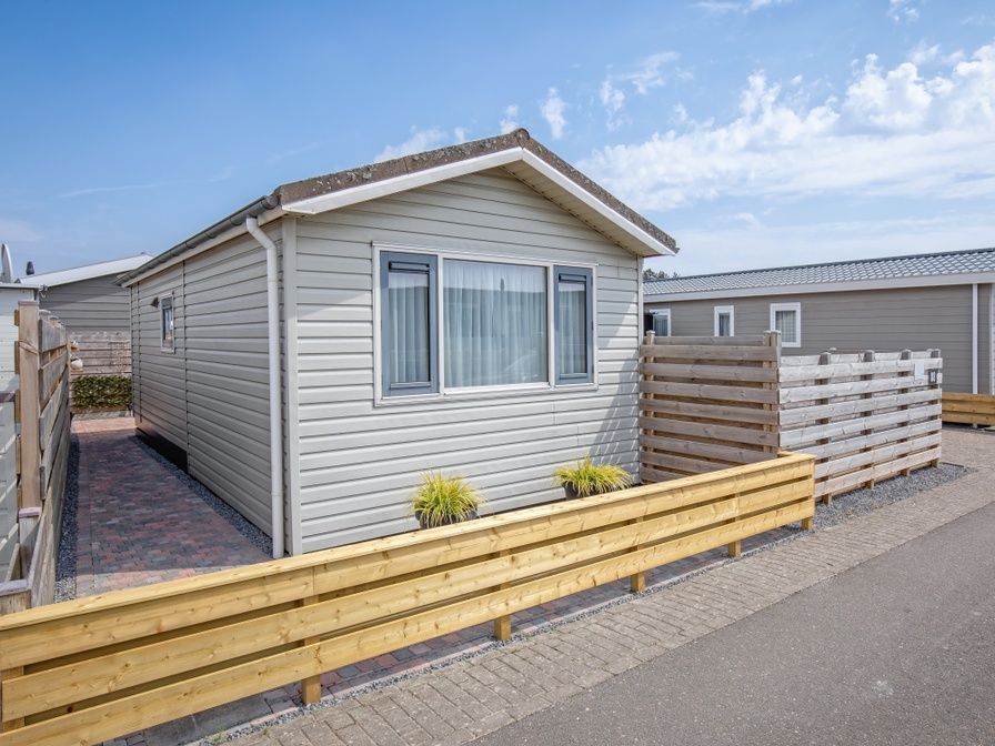 Chalet Bregkoog 88 in De Koog, Texel biedt een charmante buitenkant met moderne houten afwerking op Chaletpark Bregkoog.