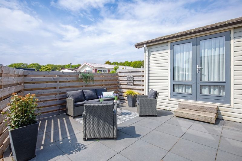 Zonnig terras met comfortabele zitplaatsen bij Chalet Bregkoog 88 in De Koog, Texel, gelegen op Chaletpark Bregkoog.