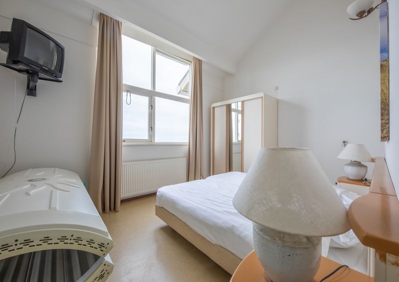 Slaapkamer met groot raam in Resort De Buteriggel - Appartement 1, biedt uitzicht en comfort in De Koog, Texel.