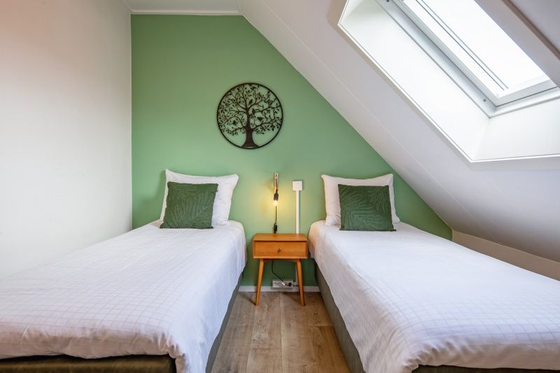 Helles Schlafzimmer mit Dachfenster und zwei Betten in De Boomleeuwerik, De Koog.