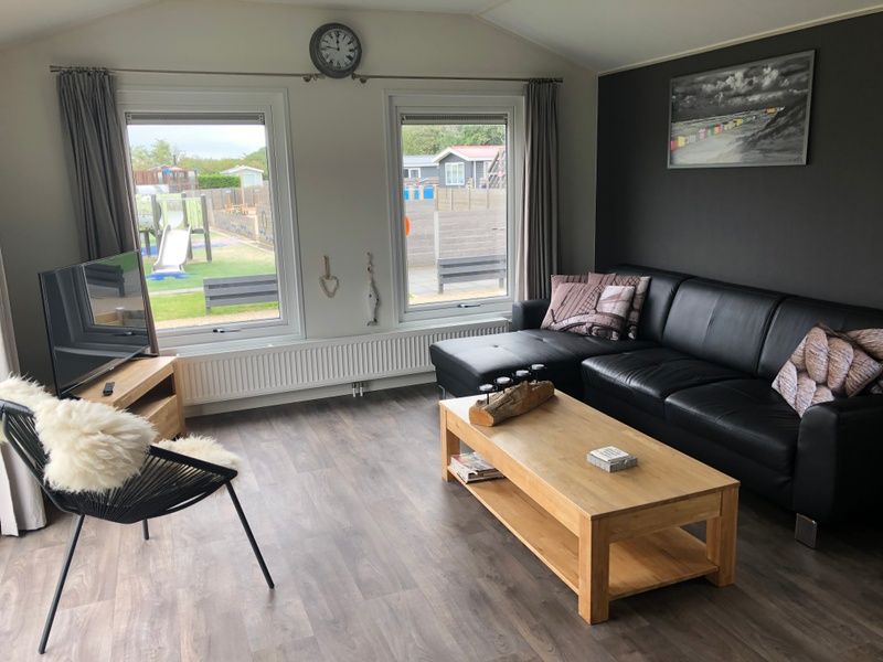 Geraeumiges Wohnzimmer mit bequemem Sofa im Chalet Bregkoog 226, De Koog, Texel.