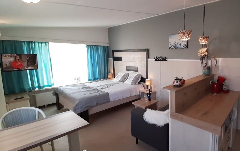 Lichte en ruime kamer in Appartement Duinzee Texel, De Koog, met comfortabele meubels en tv.