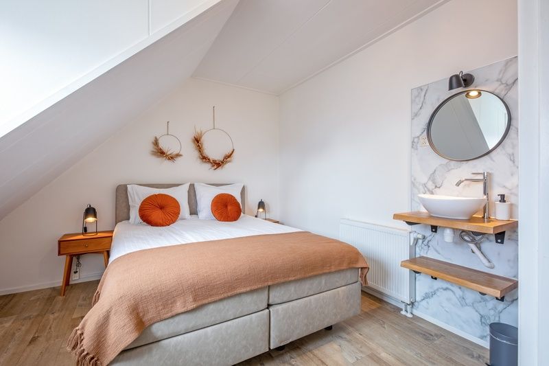 Gezellige slaapkamer in Windlust vakantiehuis De Koog Texel met moderne wastafel.
