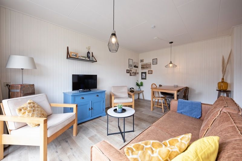 Gezellige woonkamer met tuinzicht in Windlust vakantiehuis De Koog Texel.