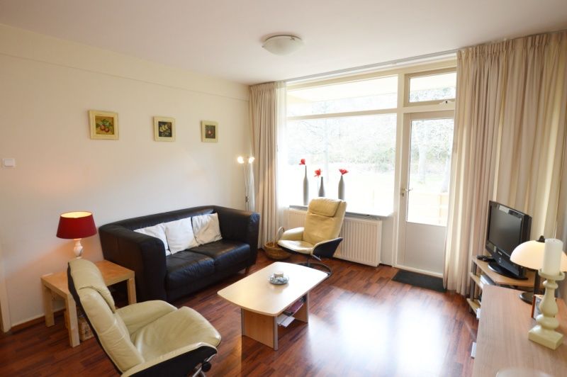 Lichte leefruimte in Appartement Kerckeland 24, De Koog, Texel met comfortabele meubels en grote ramen.