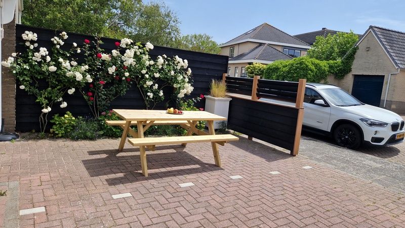 Zonnig terras van Vakantiehuis Duinzee Texel, De Koog, ideaal voor buiten dineren en ontspanning.