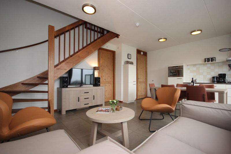 Stijlvolle woonkamer van Vakantiehuis in De Koog, Texel met moderne inrichting en gezellige zithoek, ideaal voor ontspanning op de Waddeneilanden.