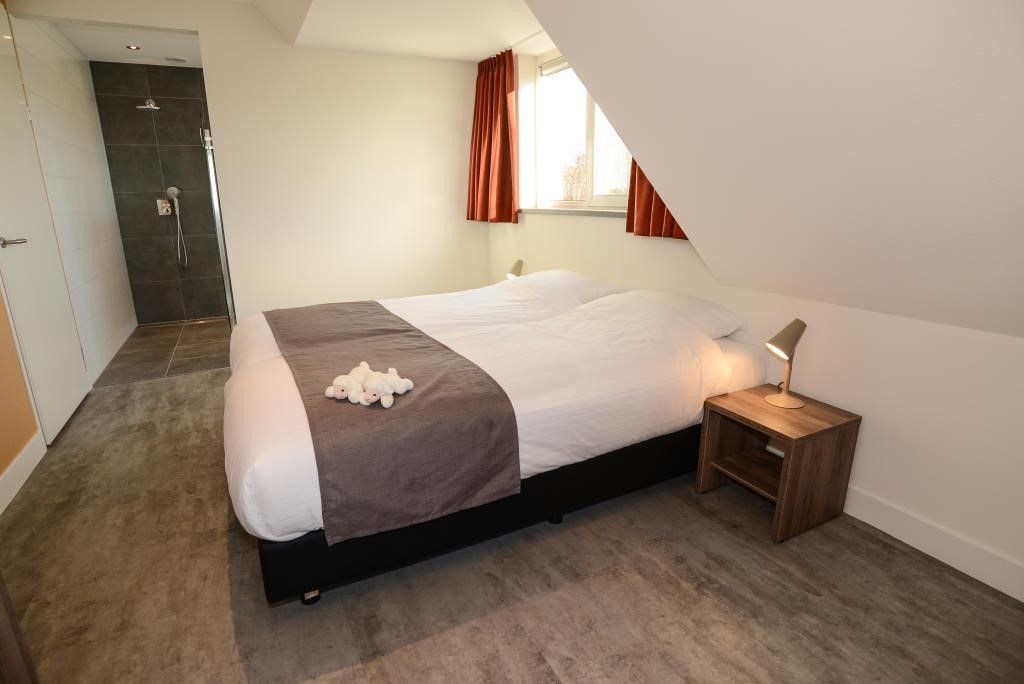 Bedroom with ensuite bathroom in 06 - Razende Bol - allotment vacation home in De Koog, Texel.