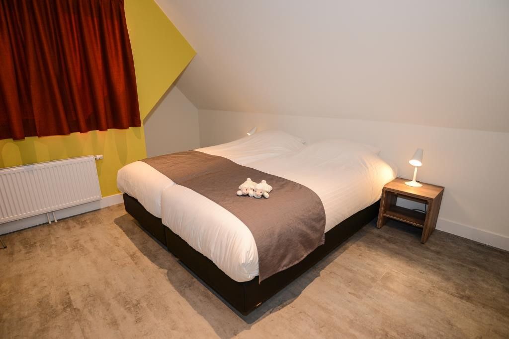 Spacious bedroom in 06 - Razende Bol - allotment vacation home in De Koog, Texel with comfortable bed.