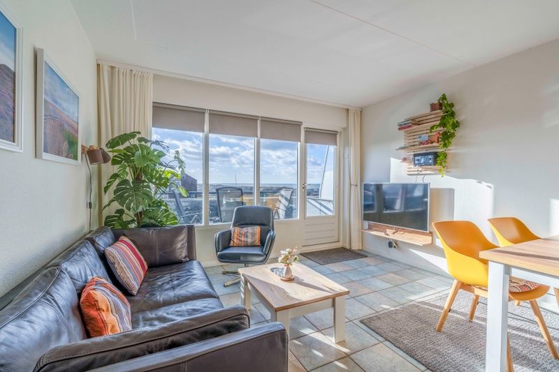 Heller Innenraum des Appartements Juliana 142 Insel- und Meerblick in De Koog, Texel mit gemuetlicher Sitzecke.
